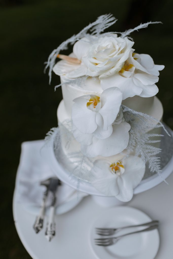 Baltas vestuvinis tortas. Baltas tortas. Vestuvinis tortas puoštas gyvomis gėlėmis.